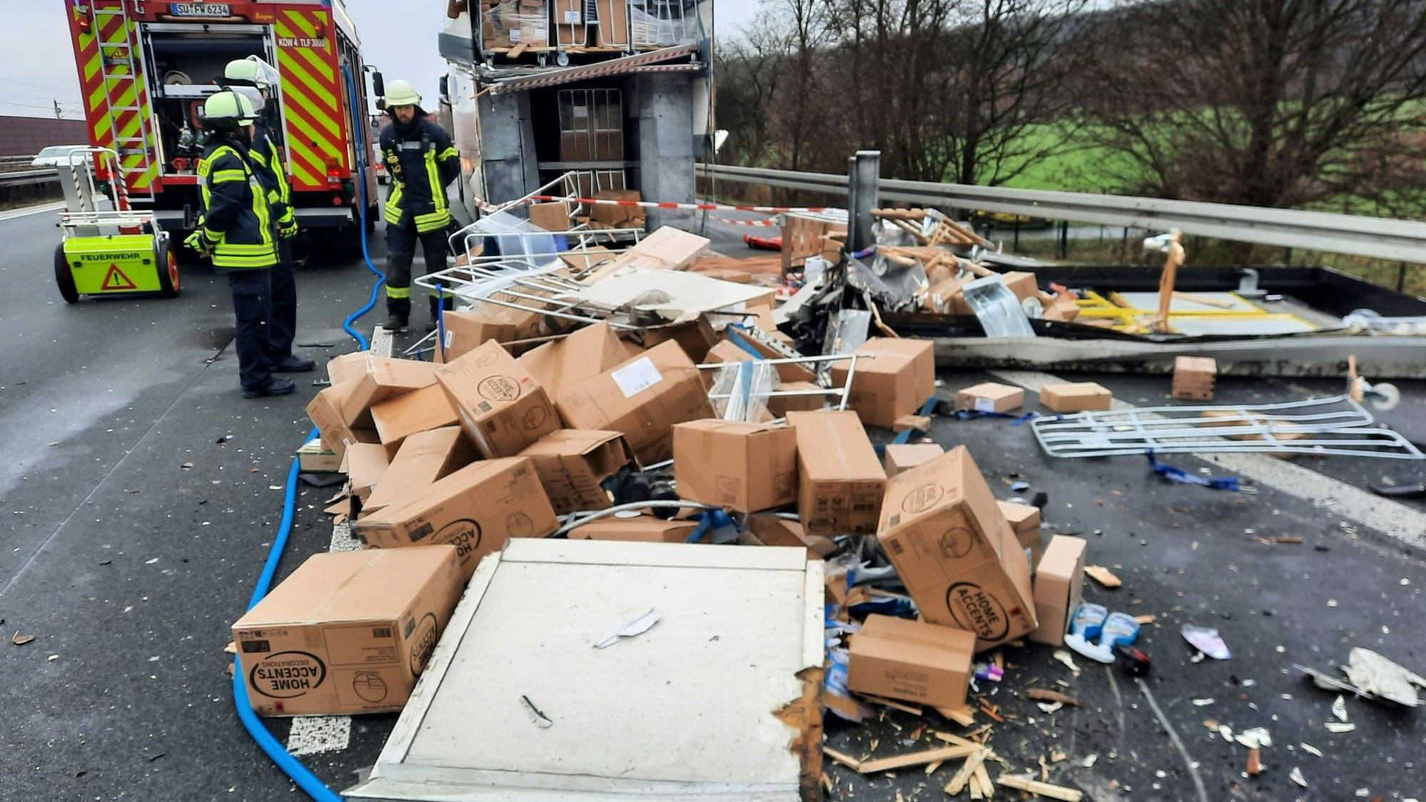 Kartons liegen auf der Autobahn, die Feuerwehr ist vor Ort.
