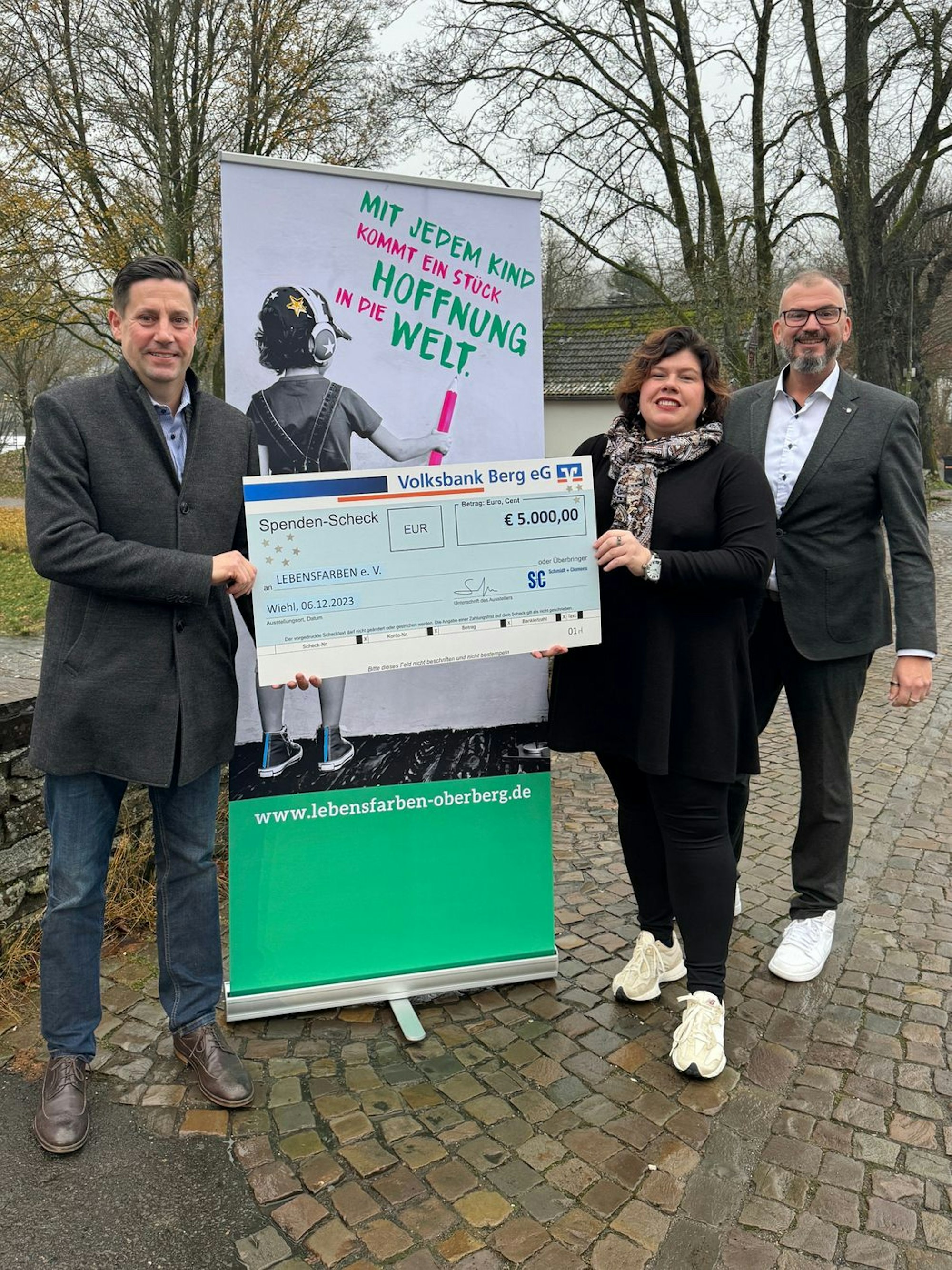 Jan Schmidt-Krayer übergibt einen großen Spendenscheck an Sandra Karsten vom Verein Lebensfarben.