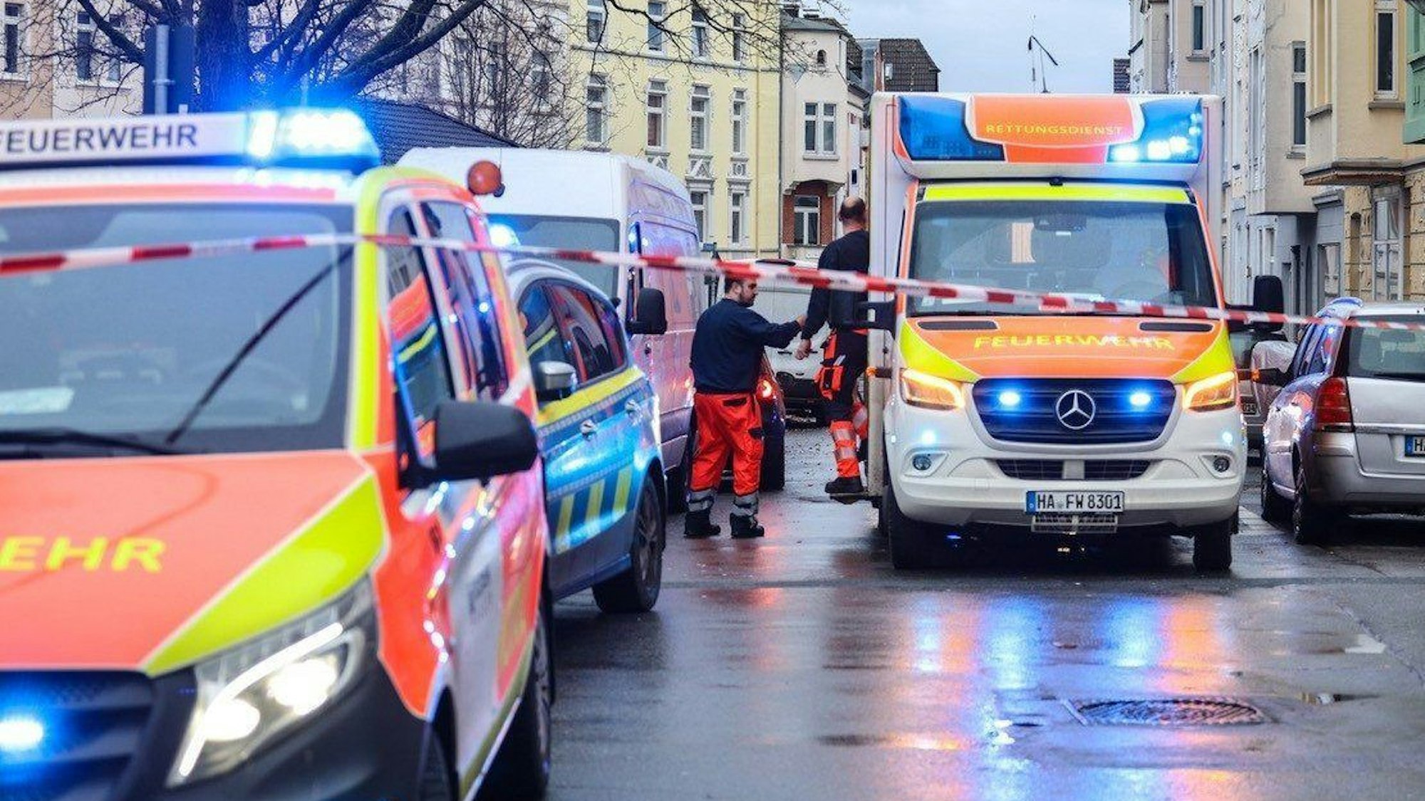Krankenwagen und Polizei stehen auf der Strasse an einem Tatort.