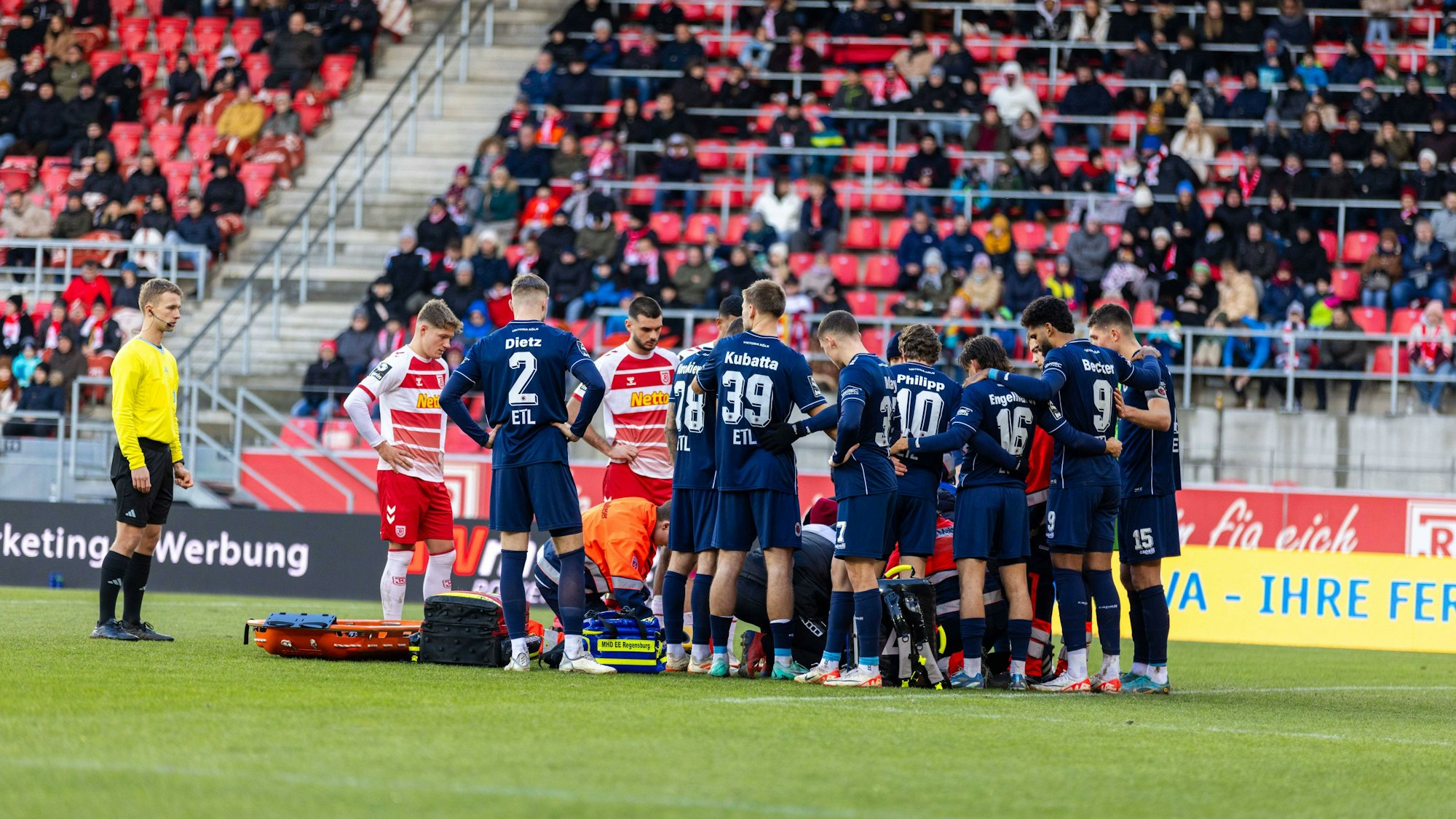 10.12.2023, Fussball, GER, Saison, 3.Liga, 18. Spieltag, SSV Jahn Regensburg - FC Viktoria Köln Spieler von beiden Mannschaften bilden einen Kreis um den verletzen Simon Handle Köln DFL REGULATIONS PROHIBIT ANY USE OF PHOTOGRAPHS AS IMAGE SEQUENCES AND/OR QUASI-VIDEO. Regensburg Bayern Deutschland Jahnstadion Regensburg *** 10 12 2023, Soccer, GER, Season, 3 League, Matchday 18, SSV Jahn Regensburg FC Viktoria Köln Players from both teams form a circle around the injured Simon Handle Köln DFL REGULATIONS PROHIBIT ANY USE OF PHOTOGRAPHS AS IMAGE SEQUENCES AND OR QUASI VIDEO Regensburg Bayern Germany Jahnstadion Regensburg