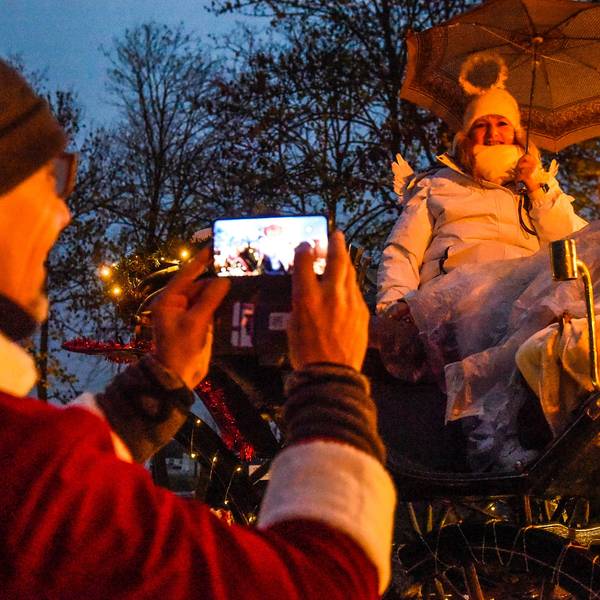 Eine Frau sitzt als Engel verkleidet auf einer Kutsche beim Lichterzug.