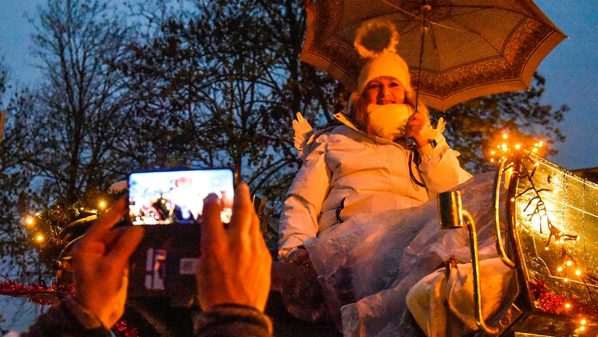 Ein Engel auf einem Zuggefährt, im Vordergrund ein Mann, der Fotos macht.
