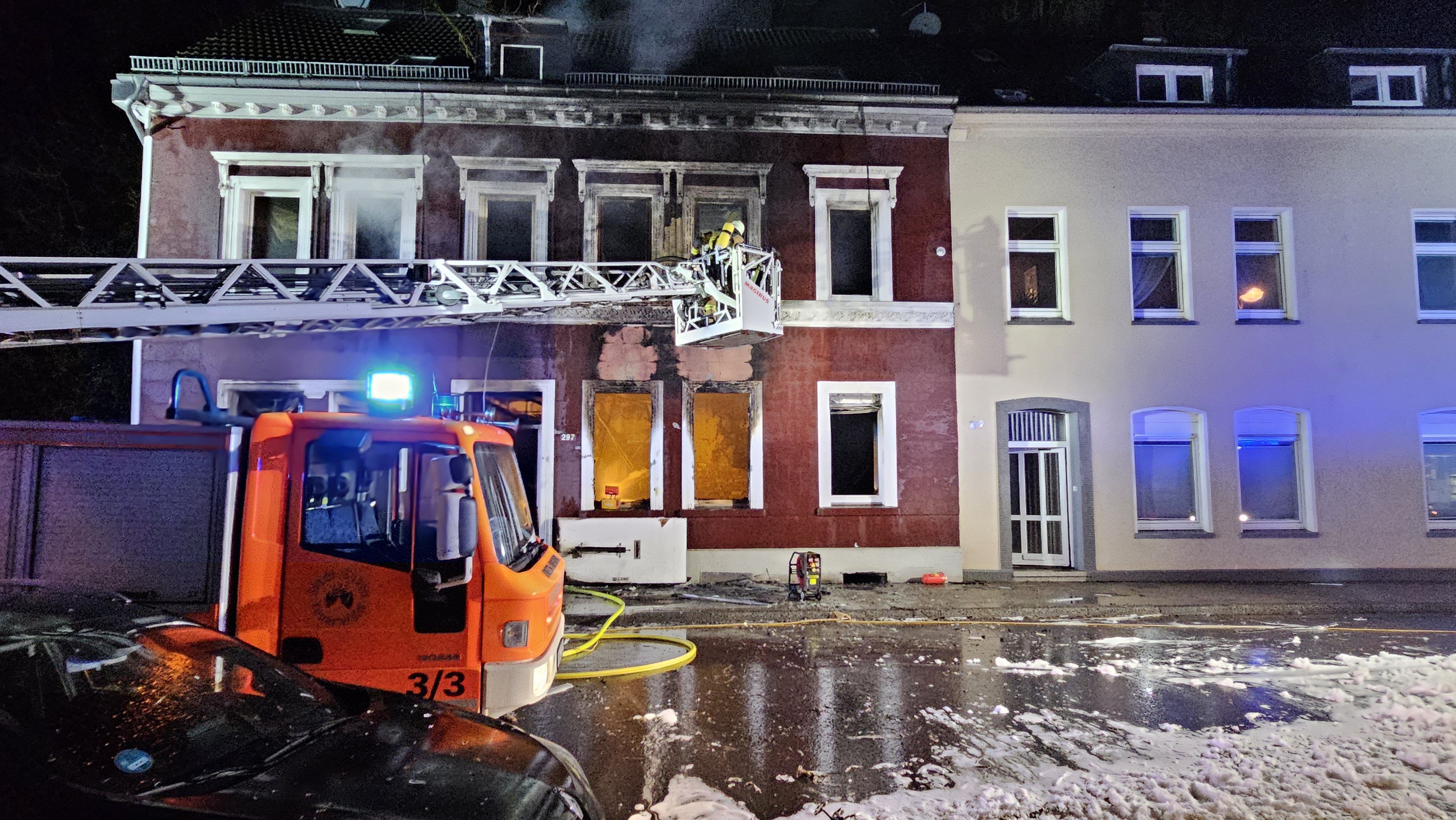 09.12.2023, Nordrhein-Westfalen, Essen: Feuerwehrleute löschen von einer Drehleiter aus in ein Haus hinein. Bei einer Explosion und einem Brand in einem Mehrfamilienhaus in Essen sind am Samstagabend mehrere Menschen verletzt worden. Ein Mensch sei aus dem Fenster gesprungen, um sich zu retten. Foto: Markus Gayk/dpa +++ dpa-Bildfunk +++