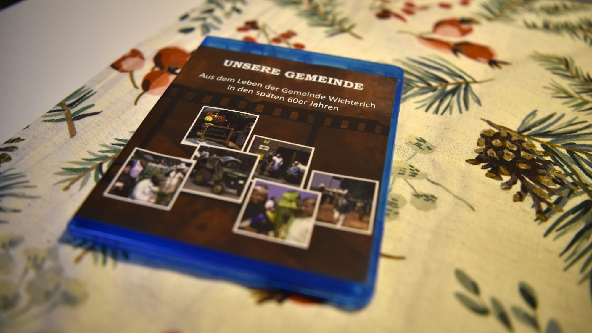 Eine Blu-Ray mit dem Titel: „Unsere Gemeinde – Aus dem Leben der Gemeinde Wichterich in den späten 60er Jahren“ liegt auf einer weihnachtlichen Tischdecke.