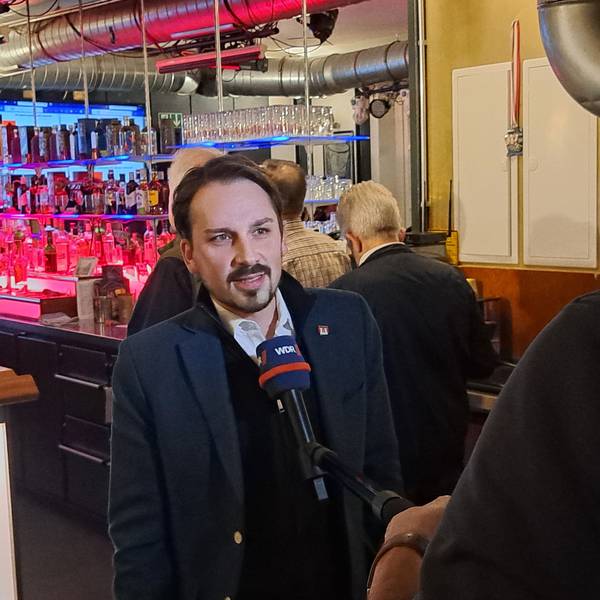 Matthias Großgarten steht an einem Mikrofon.