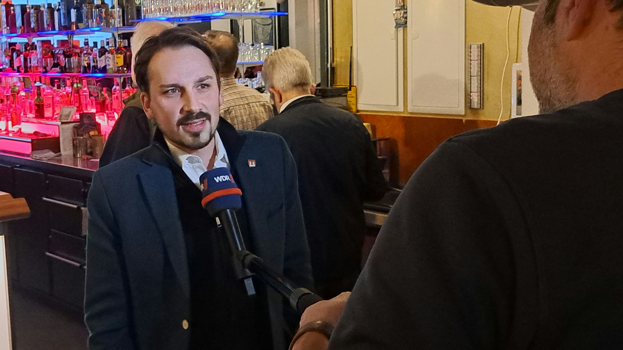 Matthias Großgarten steht an einem Mikrofon.