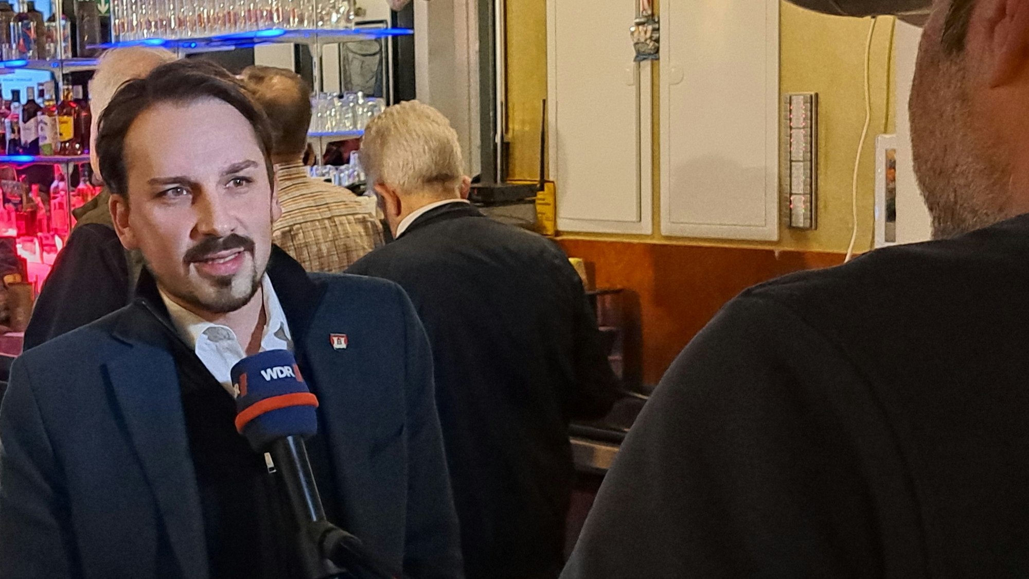 Am Wahlabend wird Wahlsieger Matthias Großgarten (SPD) im Rheidter Markthaus von einem TV-Reporter interviewt.