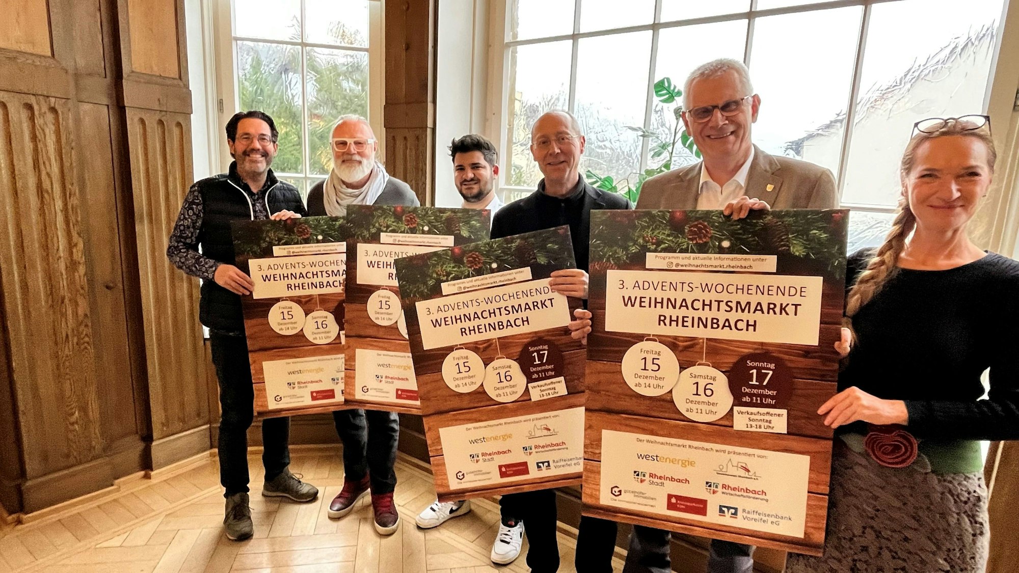 Freuen sich auf den Weihnachtsmarkt und halten Plakate mit Informationen zu dem Markt hoch (von links nach rechts): Oliver Wolf, Gewerbeverein Rheinbach, Thomas Spitz, Kulturbereich Stadt Rheinbach, Franco Amatulli, Marktbeauftragter Gewerbeverein, Joachim Rasch, Wirtschaftsförderung, Bürgermeister Ludger Banken und Citymanagerin Ramona Mignon.