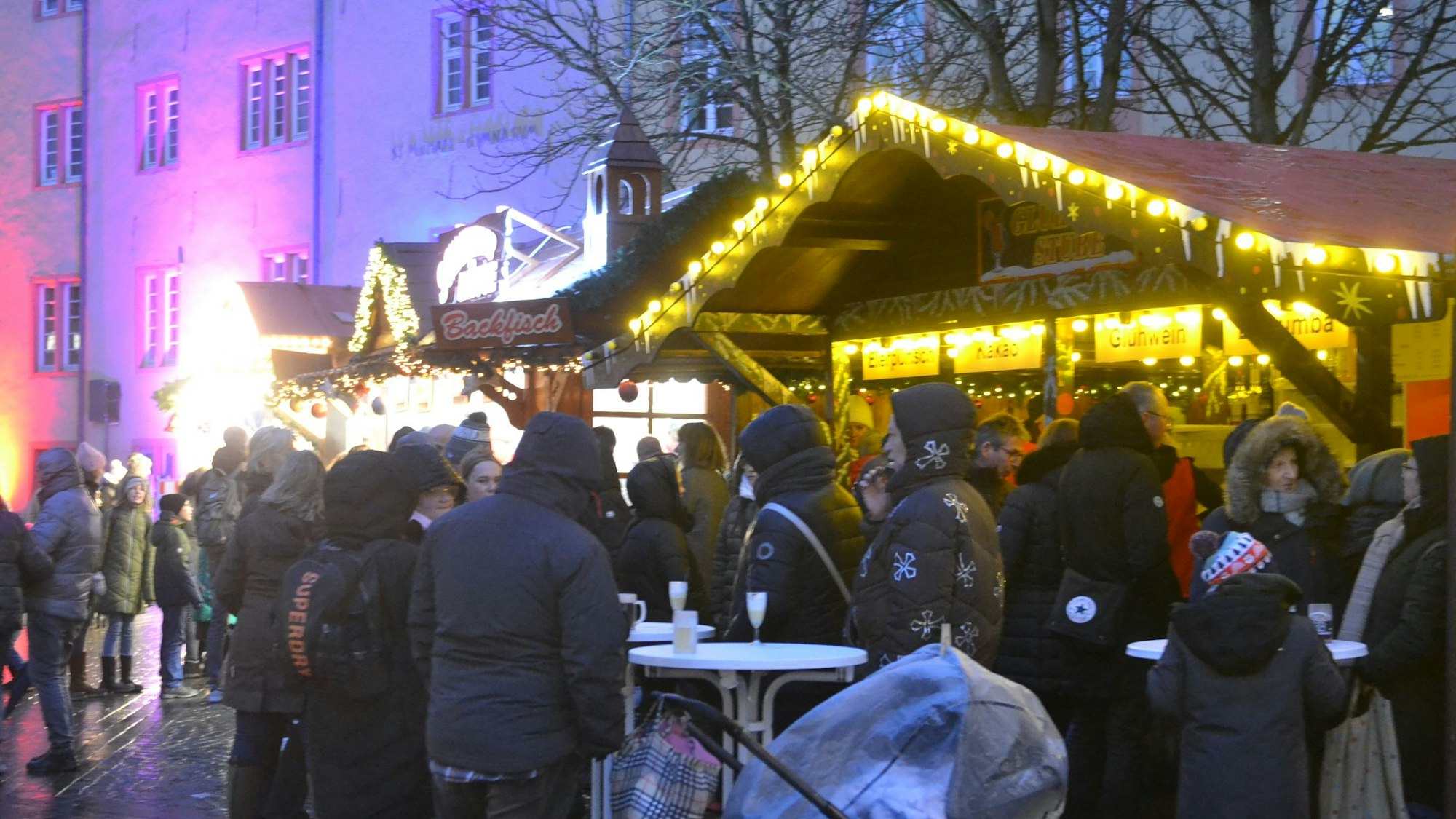 Menschen in dicken Jacken stehen an Weihnachtsmarkt in Bad Münstereifel