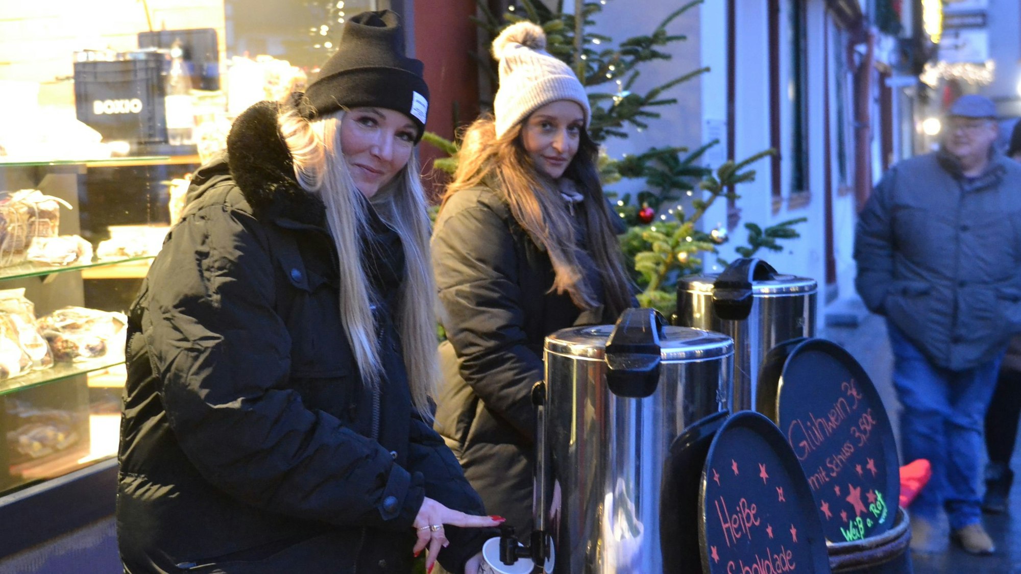Zwei junge Frauen schenken auf dem Bad Münstereifeler Weihnachtsmarkt heiße Schokolade aus.