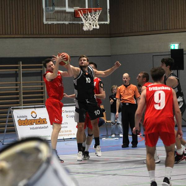 Matthias Zalfen blockt einen Ball. Im Vordergrund sind unscharf die Trommler der Erftbaskets zu erkennen.