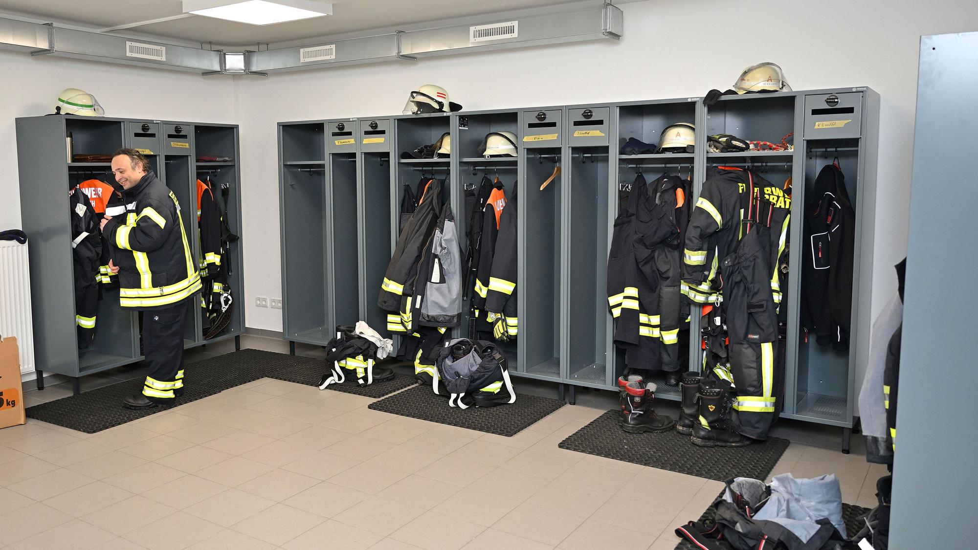 In Spinden von Feuerwehrleuten hängt Einsatzkleidung.