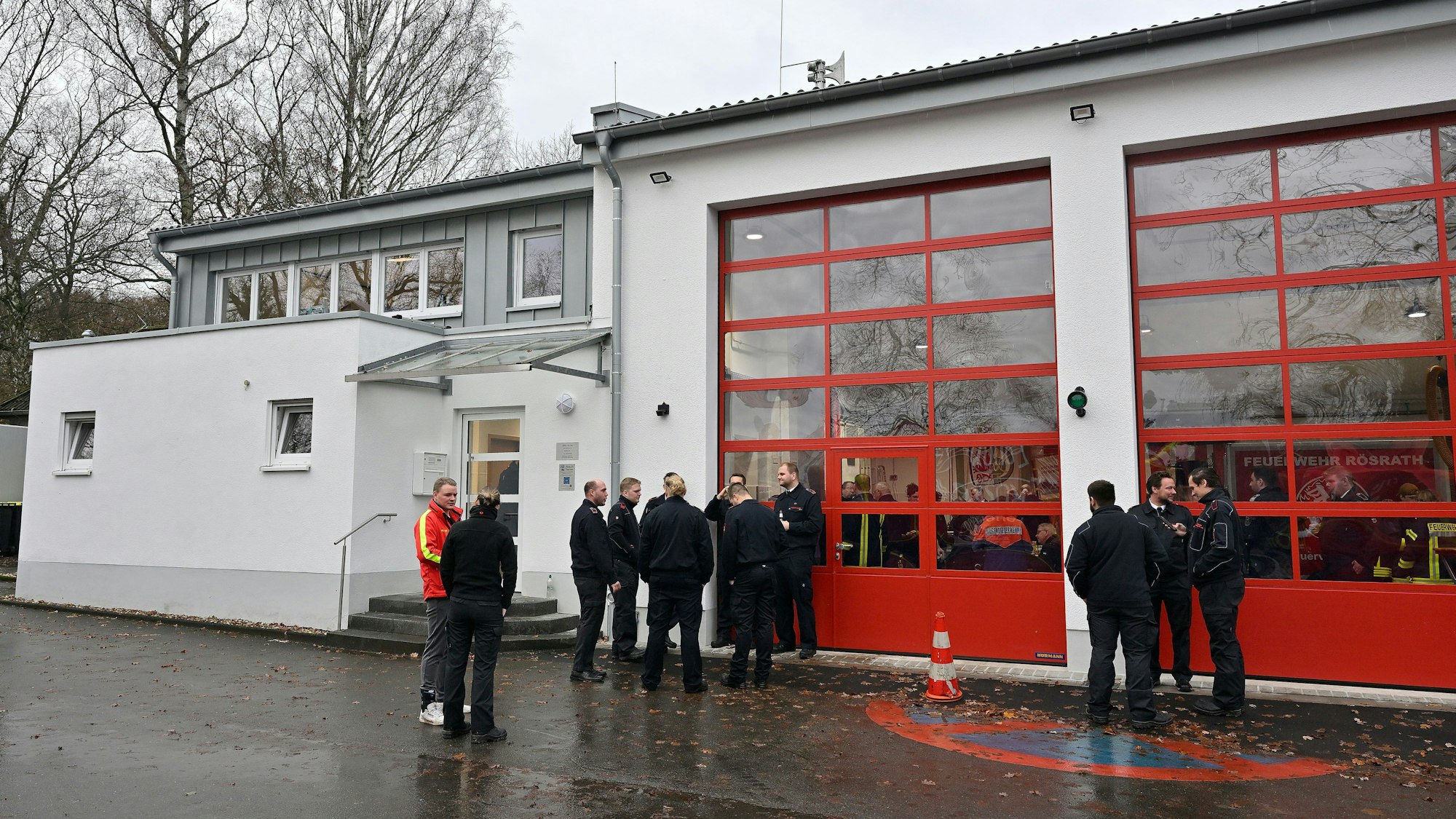 Vor dem Feuerwehrhaus Kleineichen stehen bei der Wiedereröffnung Menschen.