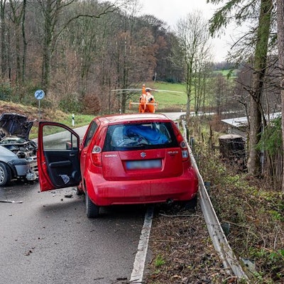 Das Foto zeigt zwei schwer beschädigte Pkw und einen Rettungshubschrauber