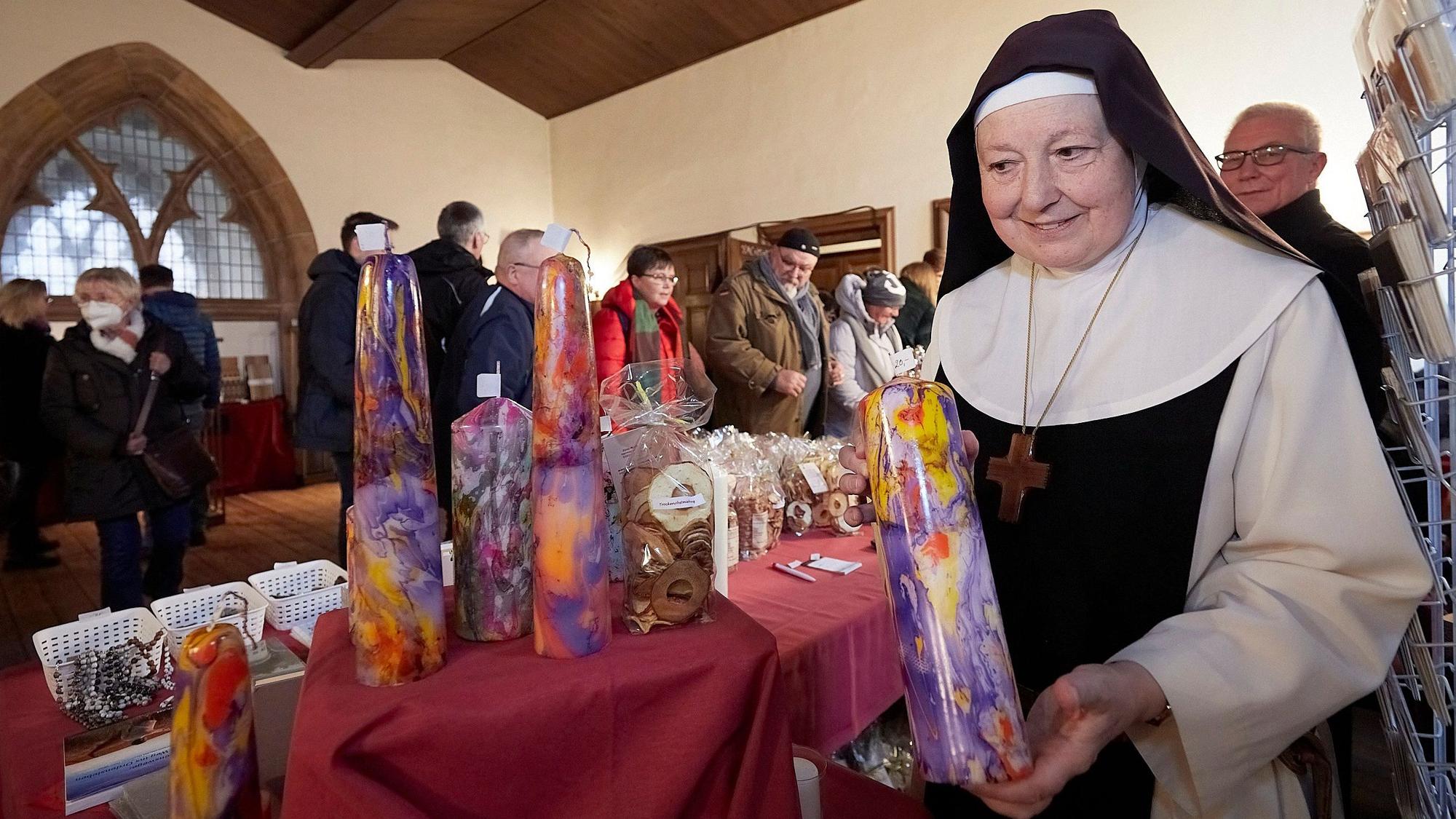 Sr. Gratia von den Trappistinnen zeigt ihre bunten selbst gemachten Kerzen.