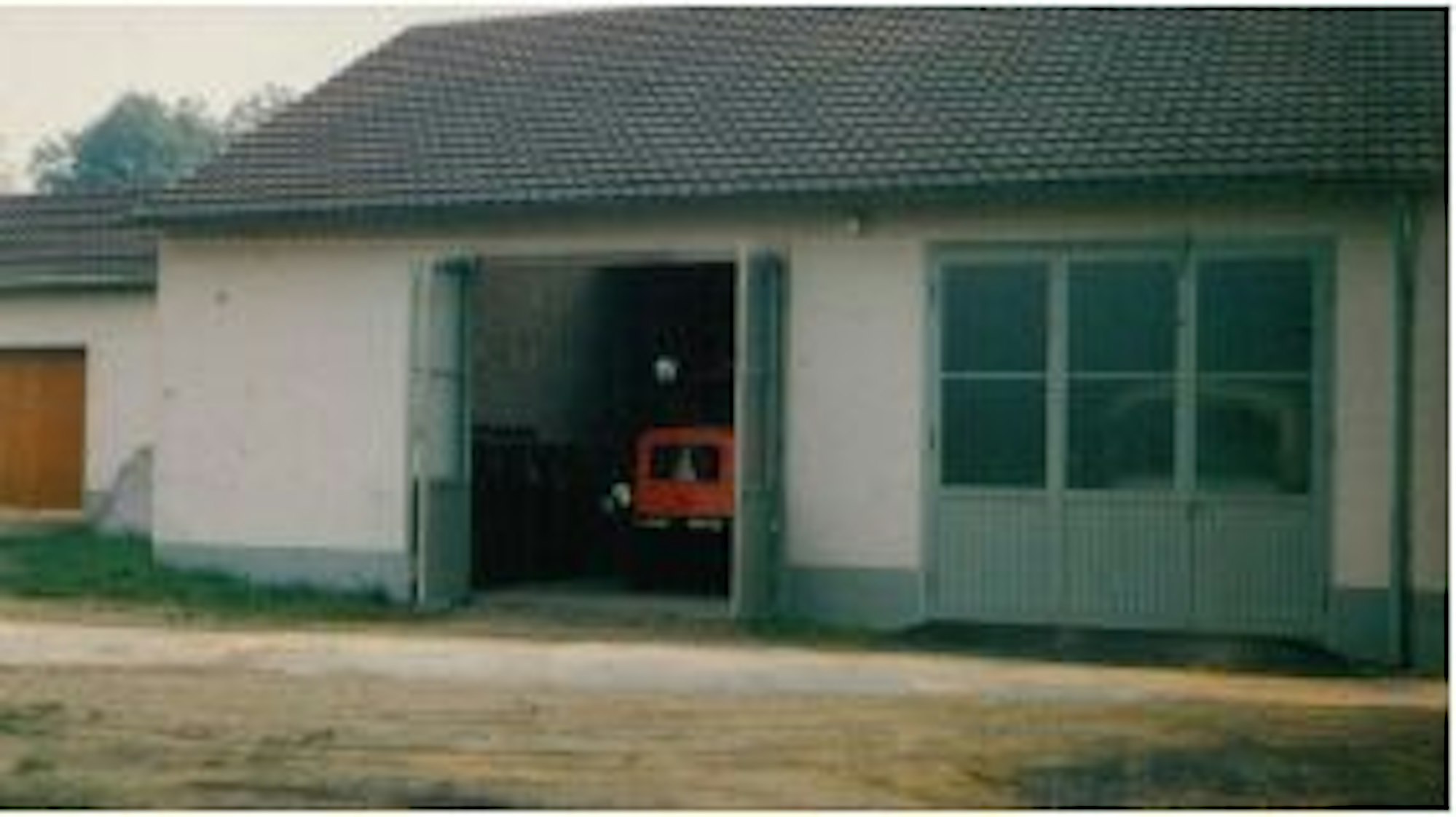 Ein historisches Foto zeigt eine Fahrzeughalle mit einem roten Lastwagen darin.