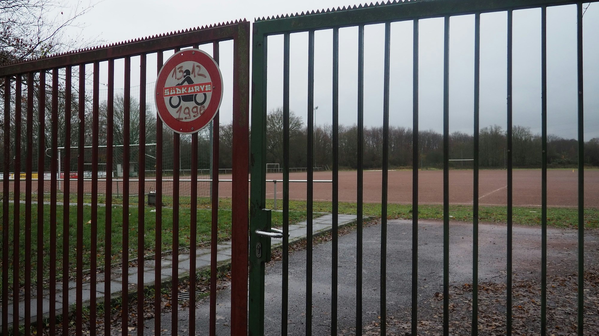 Auf dem Foto ist der Kierdorfer Sportplatz hinter einem verschlossenen Tor zu sehen.