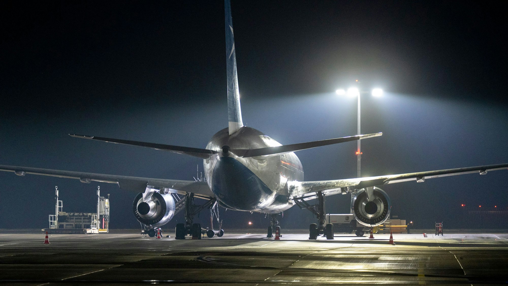 Ein Flugzeug auf dem Flugfeld bei Nacht am Flughafen Köln-Bonn
