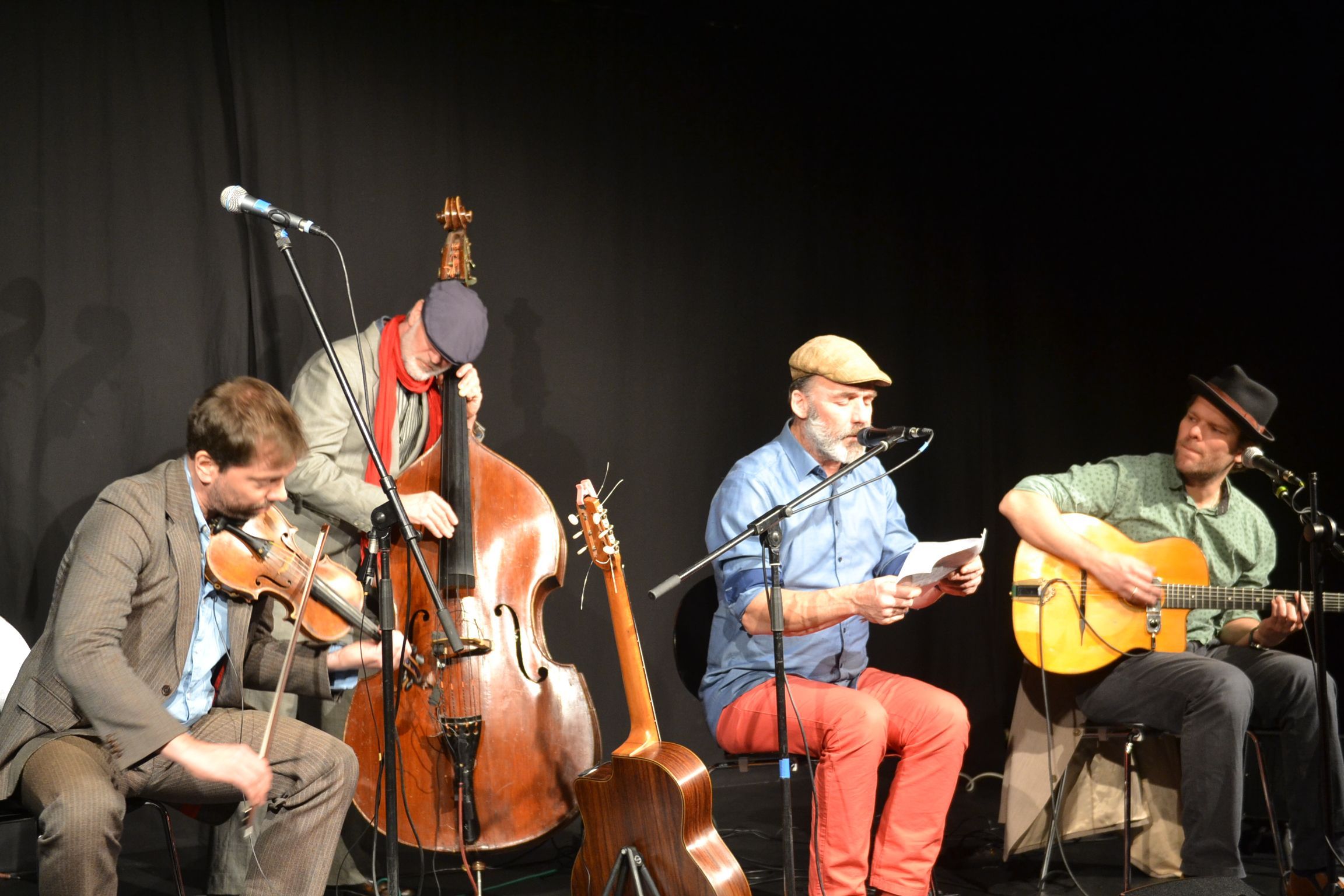 Die vier Musiker des Ensemble Monsieur Pompadour sind mit ihren Instrumenten vor schwarzem Hintergrund auf der Bühne des Theater 1 in Bad Münstereifel zu sehen.