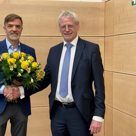 Das Bild zeigt Gerno Böll, frischgewählter Dezernent, wie er von Bürgermeister Dieter Freytag einen Blumenstrauß erhält.
