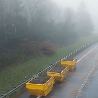 Drei mit Erdreich gefüllte Container stehen auf der B51, die seit einem schweren Unfall am Montag gesperrt ist.