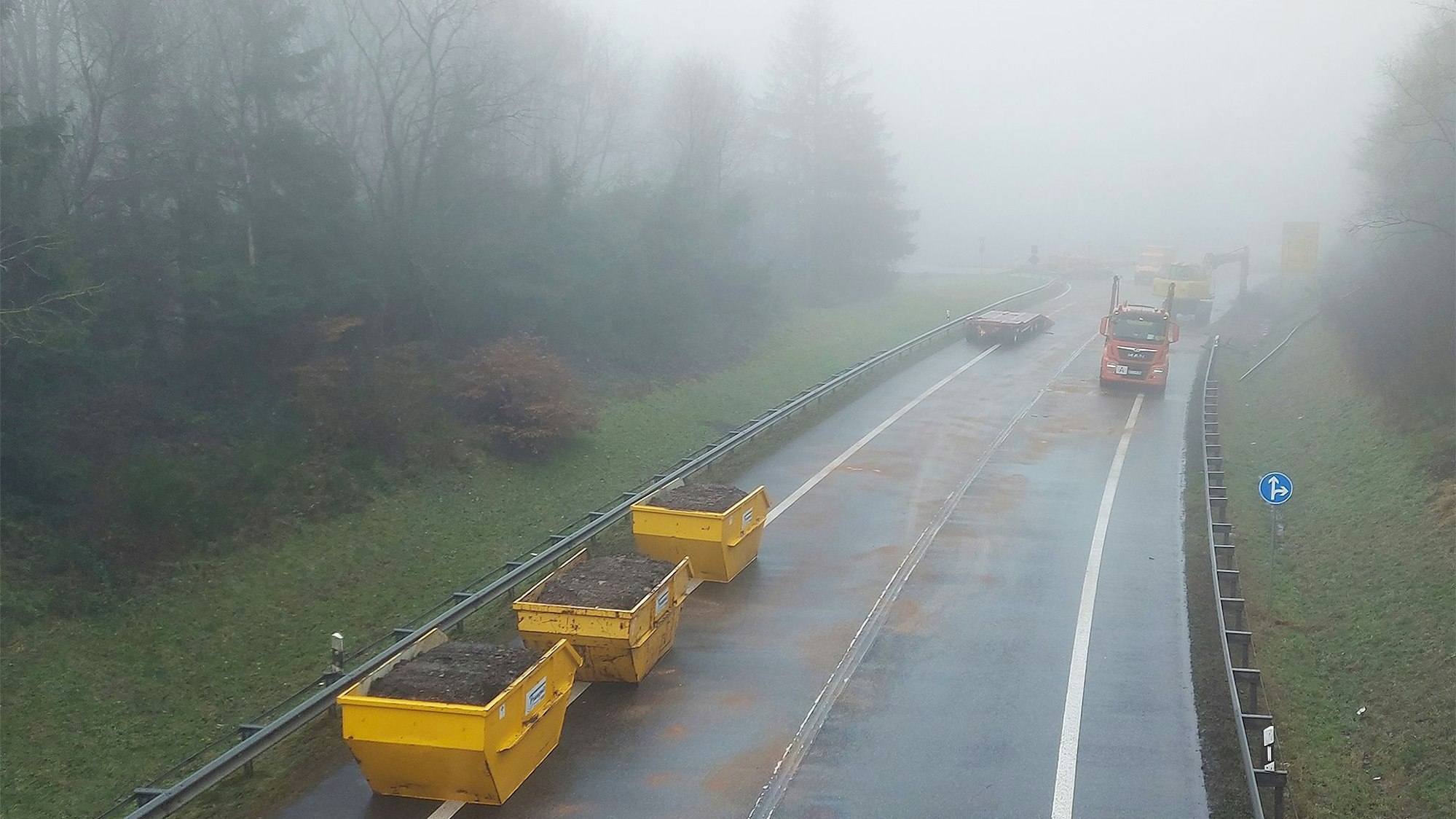 Drei mit Erdreich gefüllte Container stehen auf der B51, die seit einem schweren Unfall am Montag gesperrt ist.