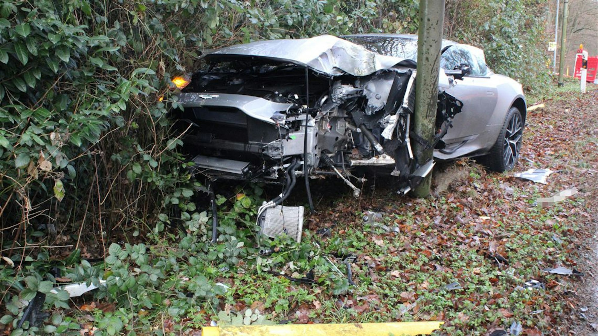 Ein völlig demoliertes Auto steht an einem Schildertafelmast.
