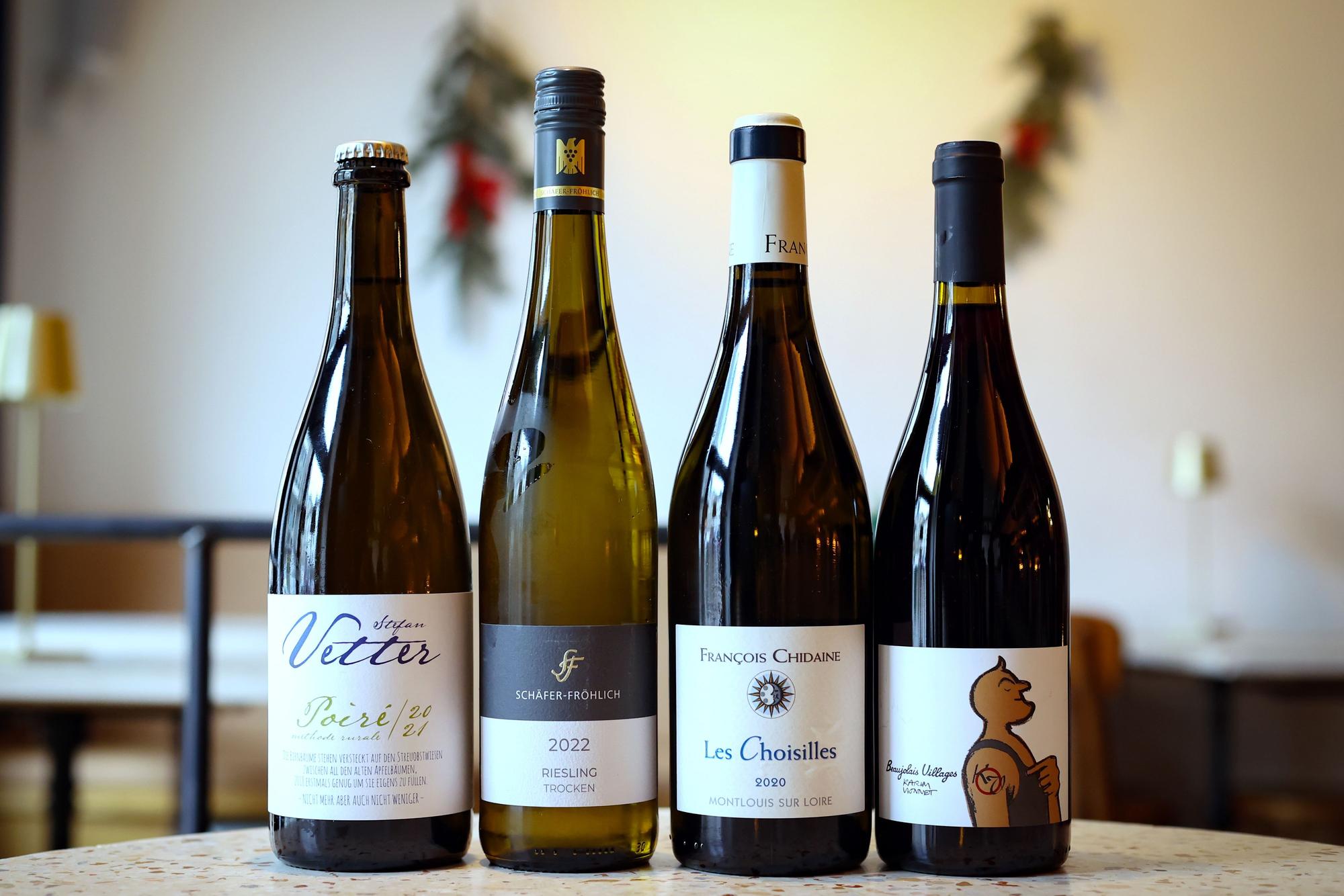 Vier Flaschen Wein stehen nebeneinander auf einem Tisch.