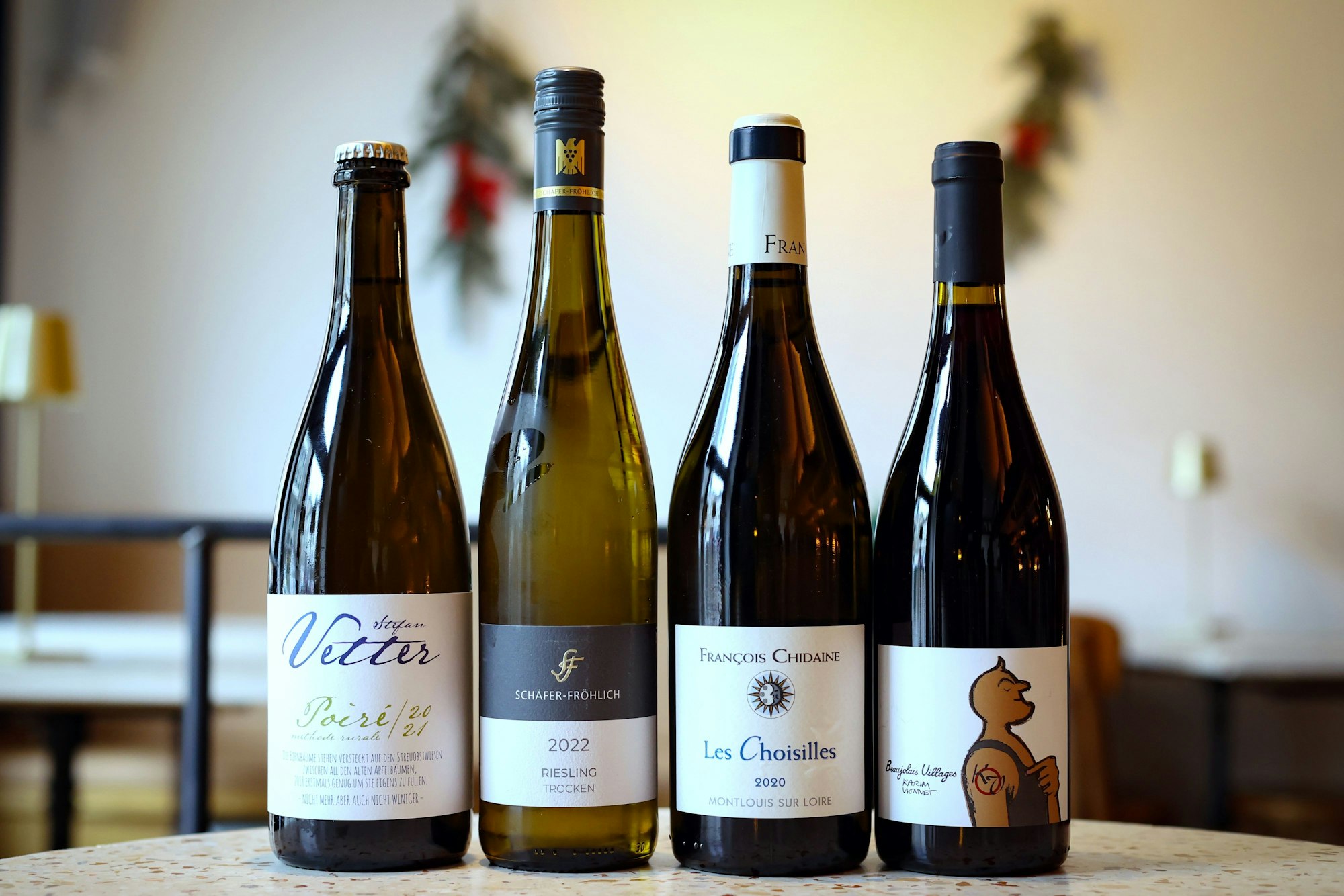 Vier Flaschen Wein stehen nebeneinander auf einem Tisch.