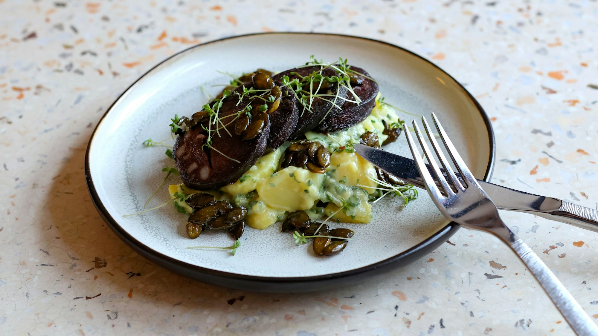 Kartoffelsalat mit gebratener Flönz und karamellisierten Kürbiskernen