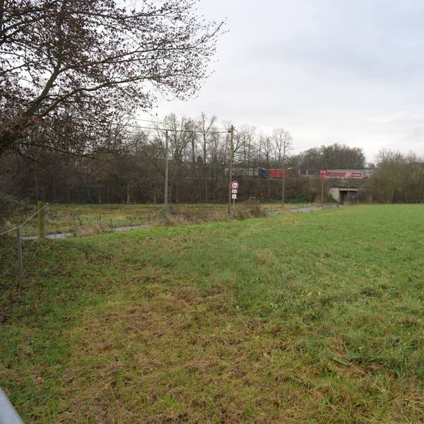 Auf einer Freifläche an der Brander Straße (l.) will die Stadt Rösrath Wohncontainer für Geflüchtete aufstellen. Sie grenzt direkt an die Autbahn A3 (im Hintergrund).
