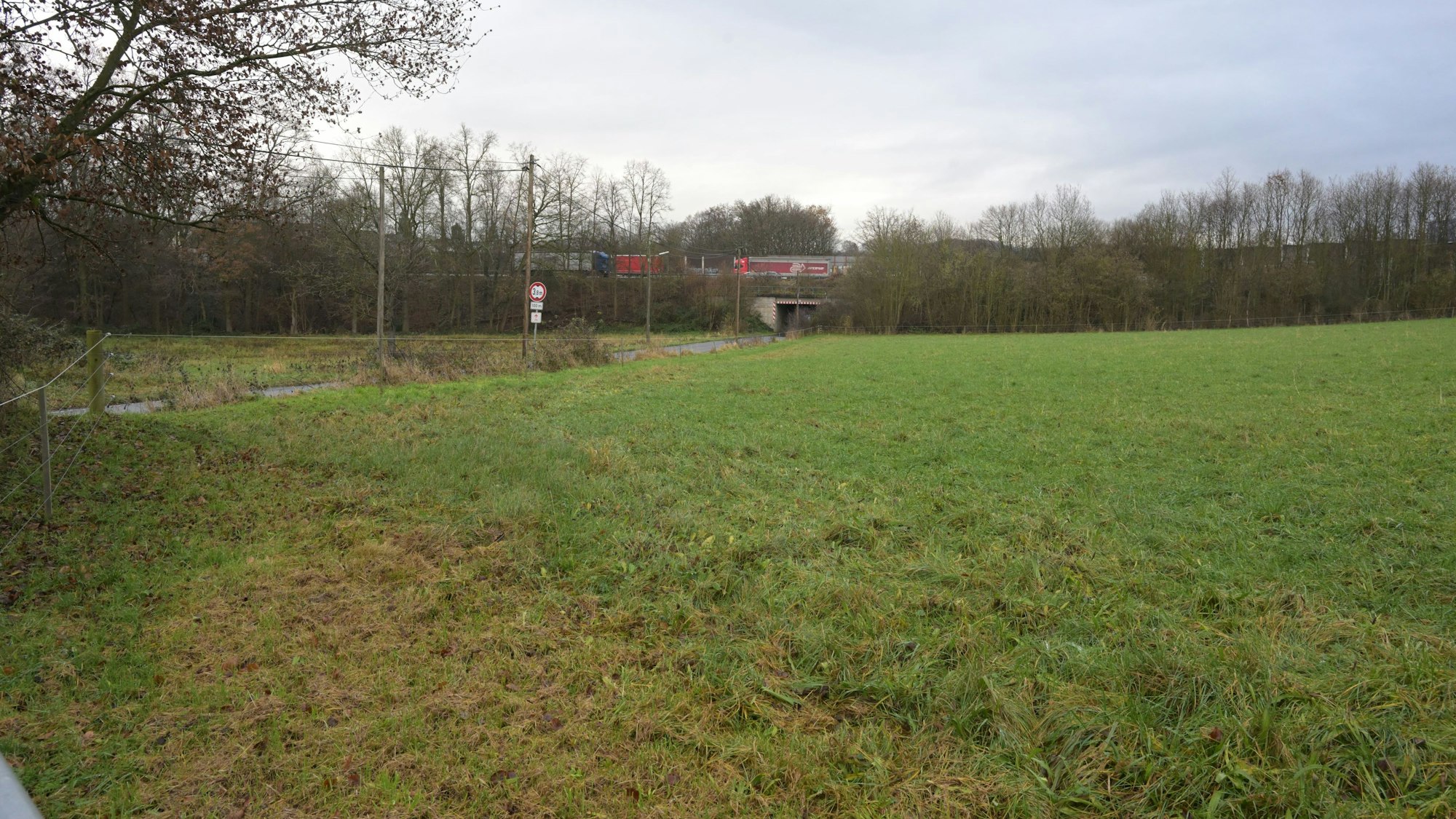 Auf einer Freifläche an der Brander Straße (l.) will die Stadt Rösrath Wohncontainer für Geflüchtete aufstellen. Sie grenzt direkt an die Autbahn A3 (im Hintergrund).