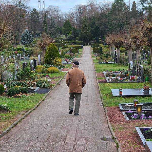 Ein Mann geht über einen Friedhof.