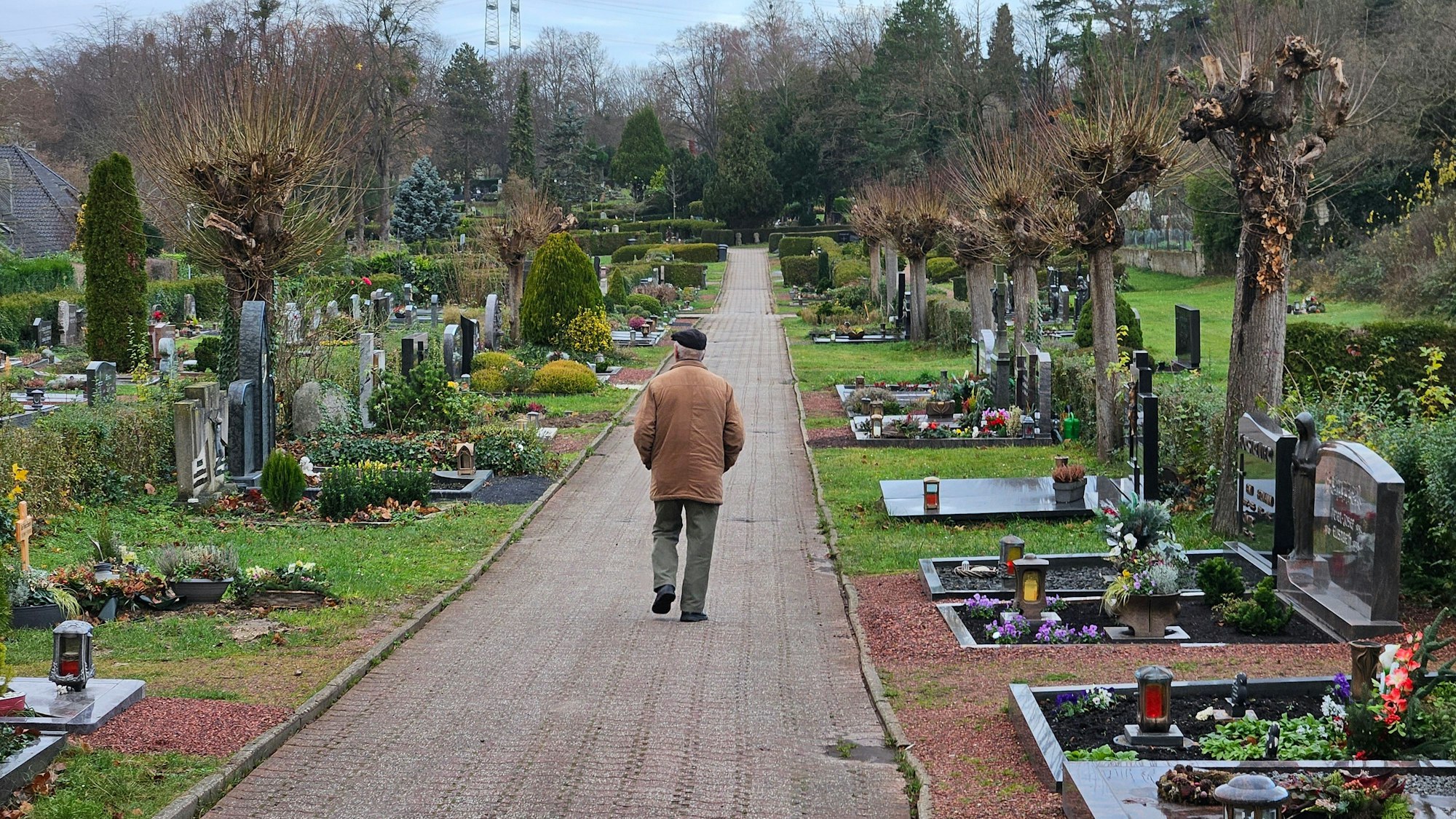 Ein Mann geht über einen Friedhof.