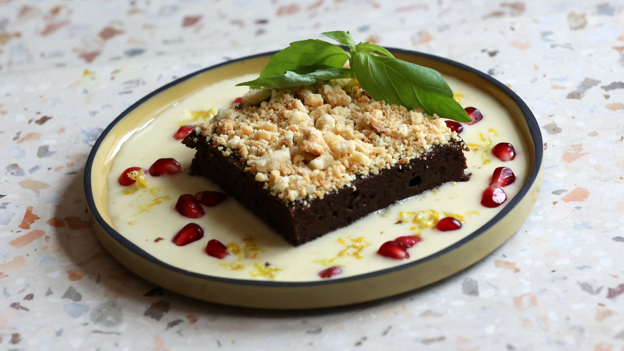Der Schokobrownie mit Lemon Curd und Granatapfelkernen, karamellisierter weißer Schokolade und Basilikum