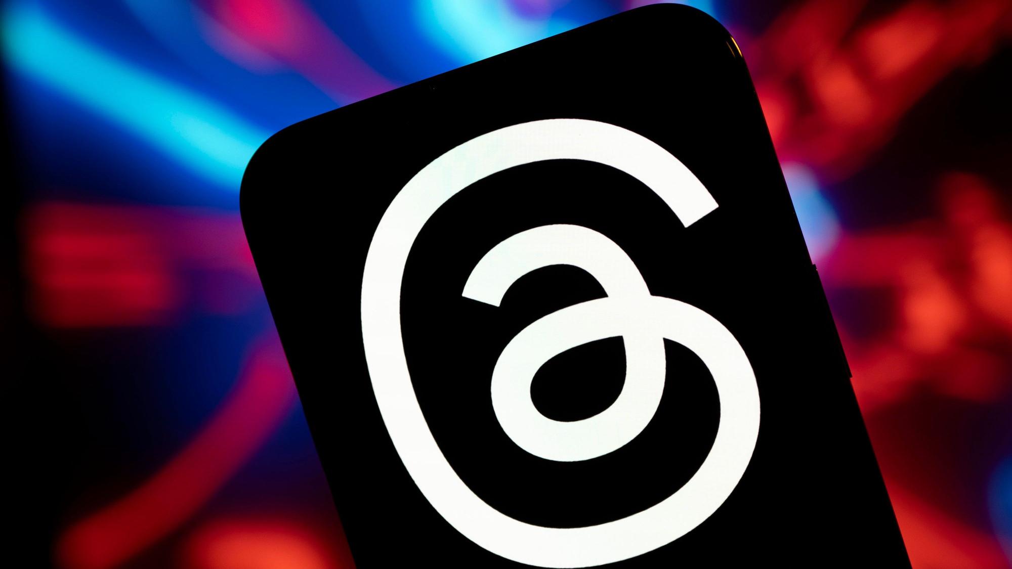 Das Logo von Threads. Ein weißer Faden auf schwarzem Grund.