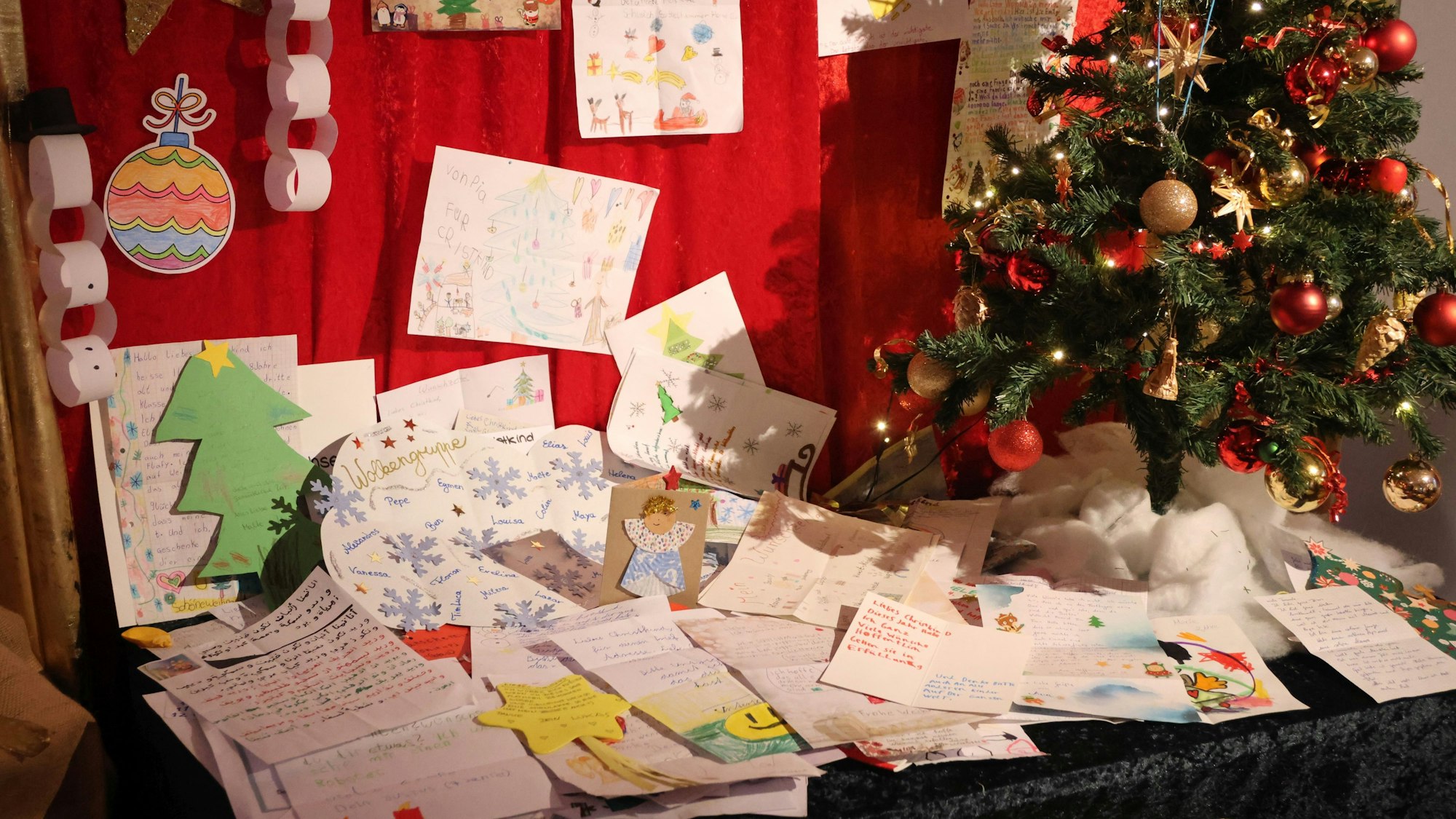 Ein weihnachtlich dekorierter Tisch voller Wunschzettel.
