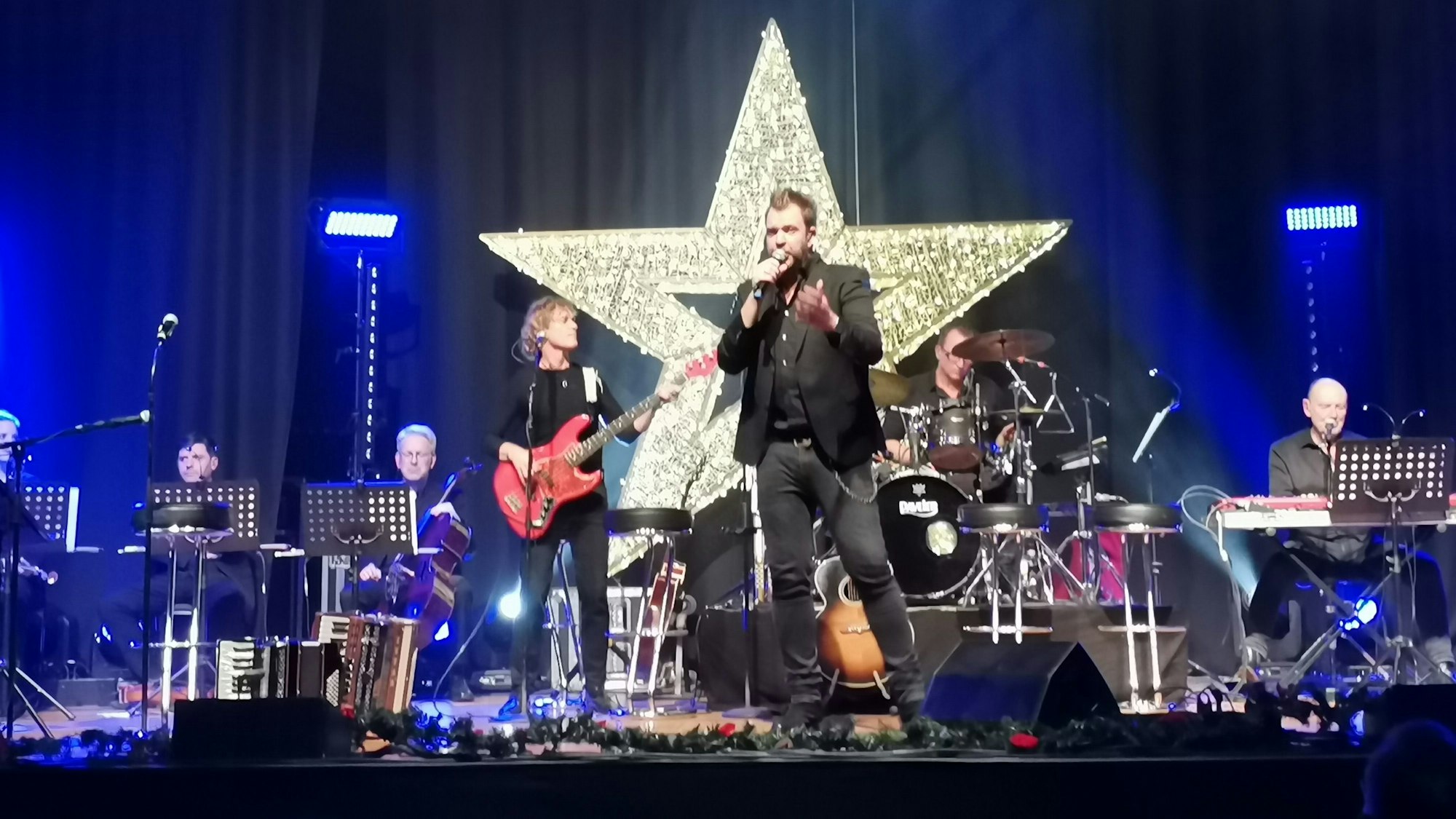 Die Band Paveier vor einem großen leuchtenden Stern auf der Bühne im Feierabendhaus Knapsack.