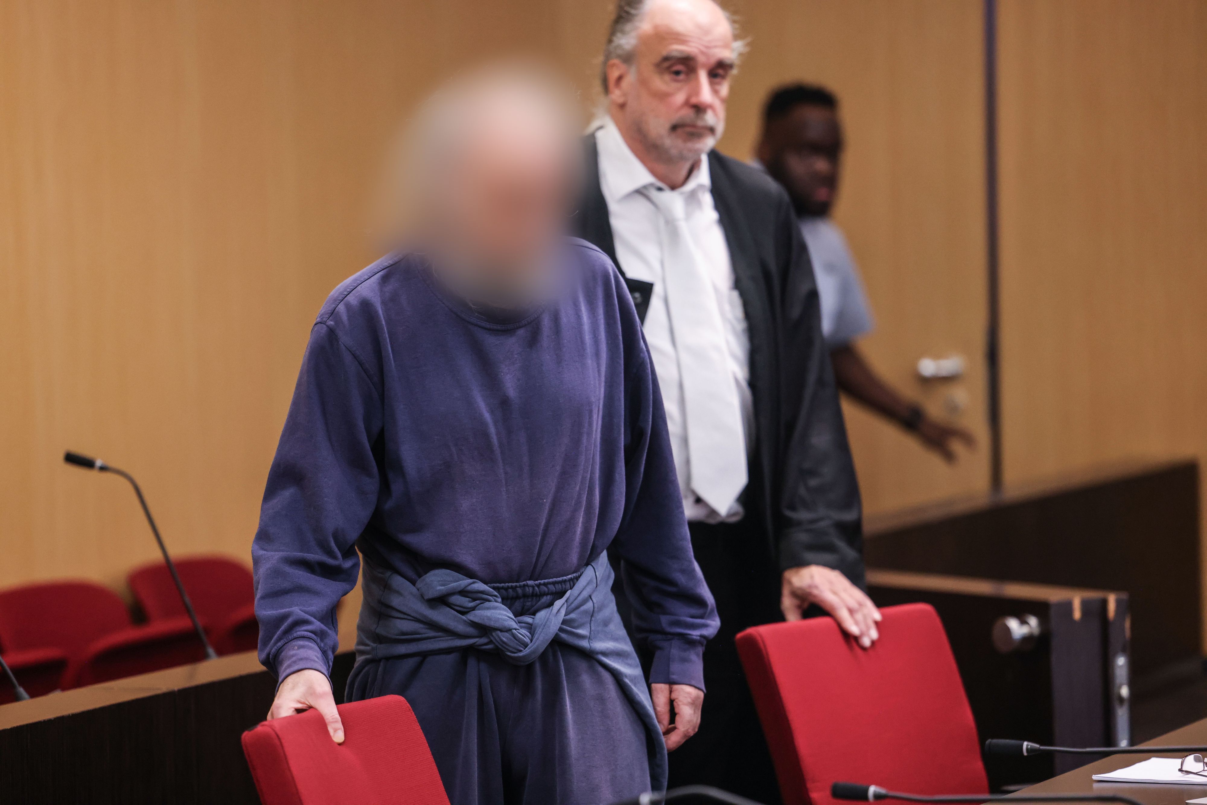Der Angeklagte kommt neben seinem Anwalt in den Gerichtssaal.