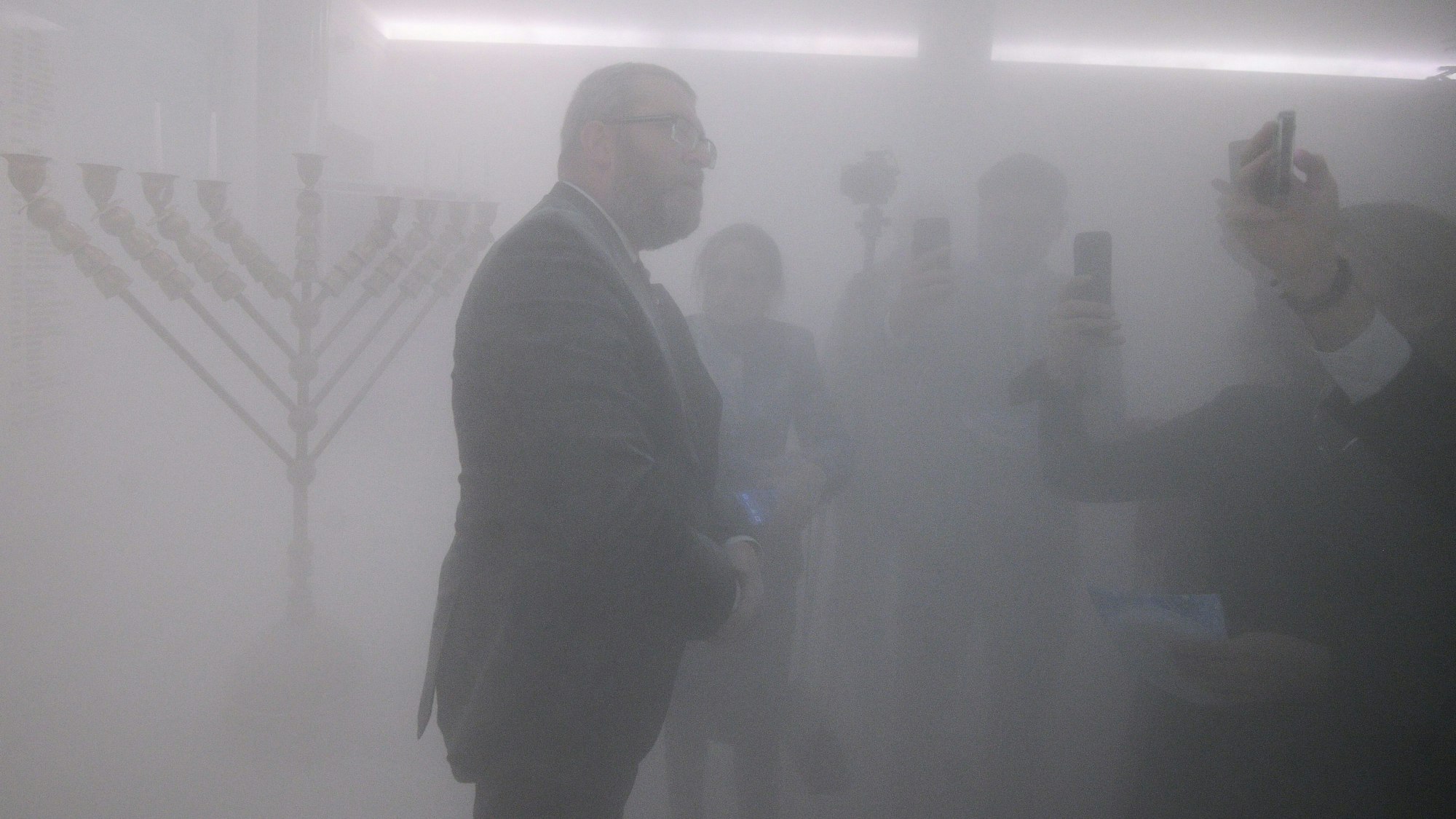 Der rechtsradikale polnische Politiker Grzegorz Braun kurz nach dem er die Chanukka-Kerzen mit einem Feuerlöscher im polnischen Parlamentsgebäude gelöscht hat. Im Hintergrund ist Magdalena Gudzinska von der jüdischen Gemeinde zu sehen.