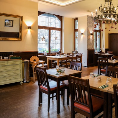 Rustikale Holztische und Stühle, gemütliche Atmosphäre.