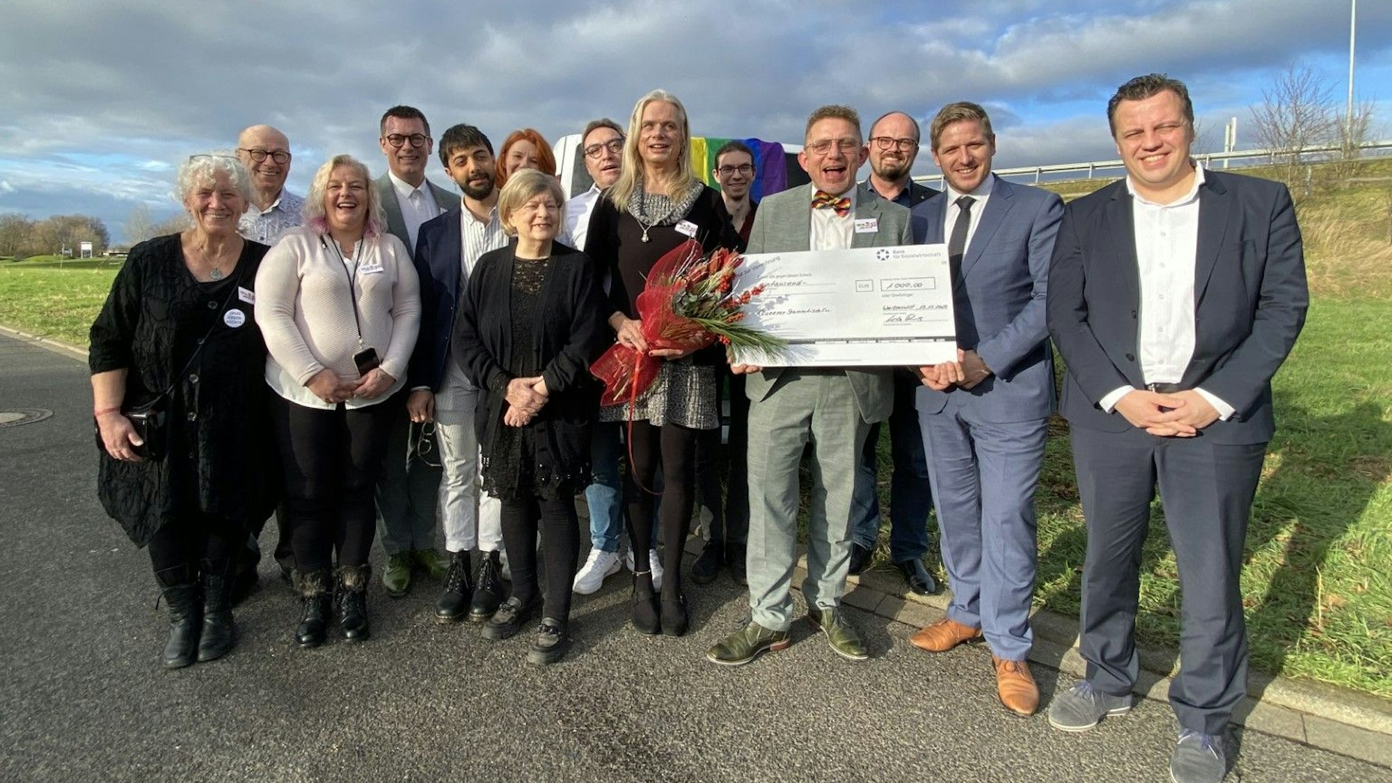 Die Mitglieder des Queeren Stammtischs Euskirchen stehen gemeinsam mit Euskirchens Bürgermeister und Landrat Markus Ramers vor ihrem Wagen mit Regenbogenflagge.