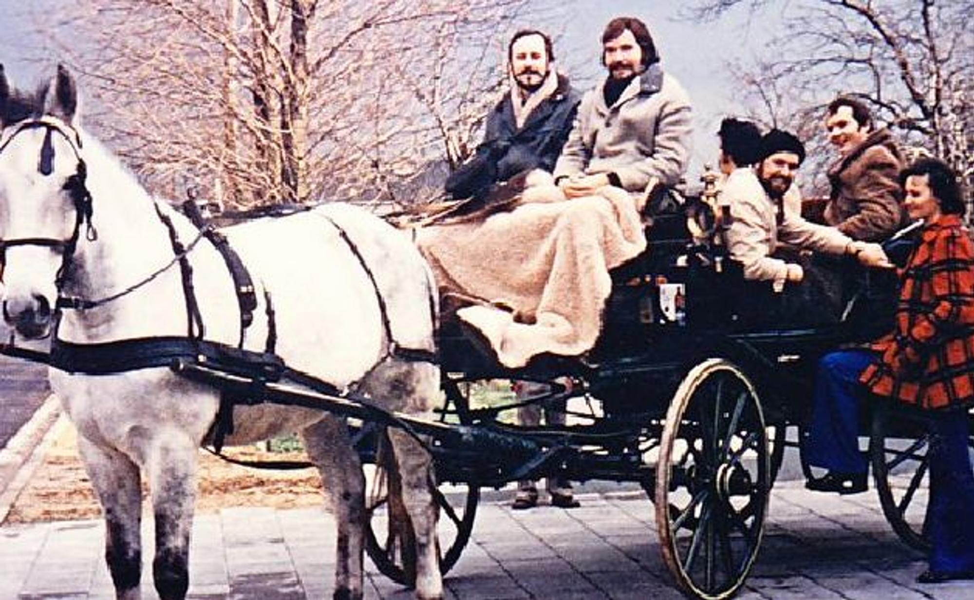 Männer und Frauen sitzen auf einer Kutsche, vor die ein Pferd gespannt ist.