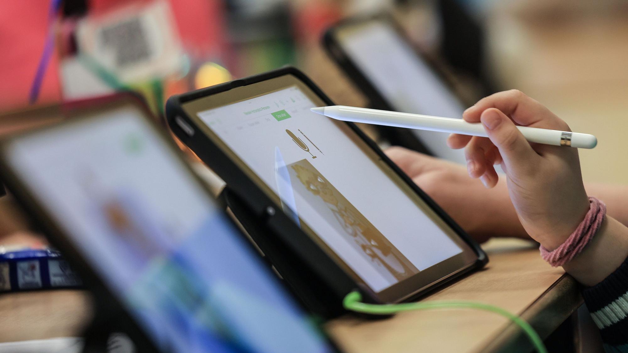Eine Hand vor einem iPad.