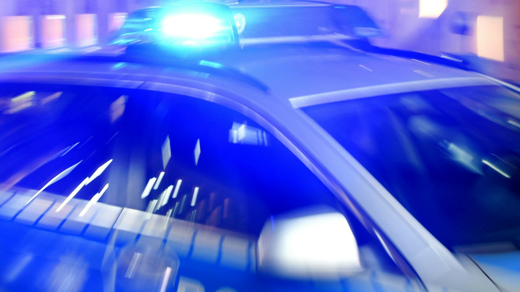 Ein Streifenwagen der Polizei steht mit eingeschaltetem Blaulicht auf der Straße. (Symbolbild)
