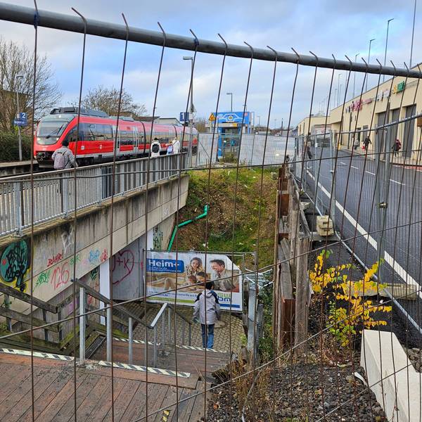 Eine Treppe, die zu einem Bahnsteig führt, ist teils von einem Bauzaun umgeben.