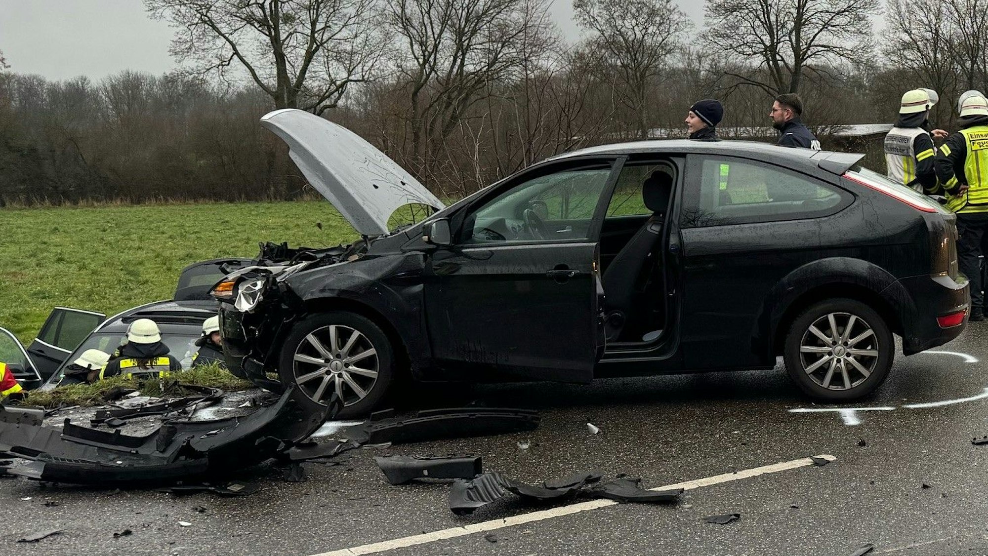 Das Bild zeigt mehrere Einsatzkräfte an der Unfallstelle zwischen beschädigten Autos.