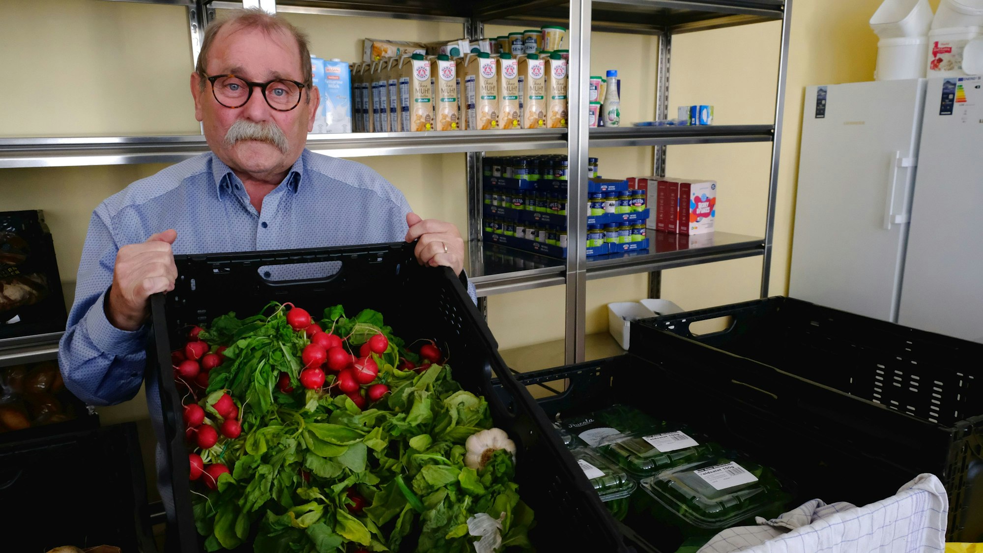 Wolfgang Weilerswist mit einer Gemüsekiste voller Radieschen in den Räumen der Mechernicher Tafel.