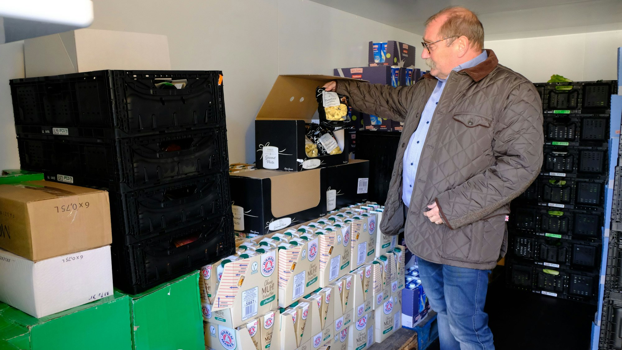 Wolfgang Weilerswist begutachtet Lebensmittel, die in einem Kühlraum gelagert sind.