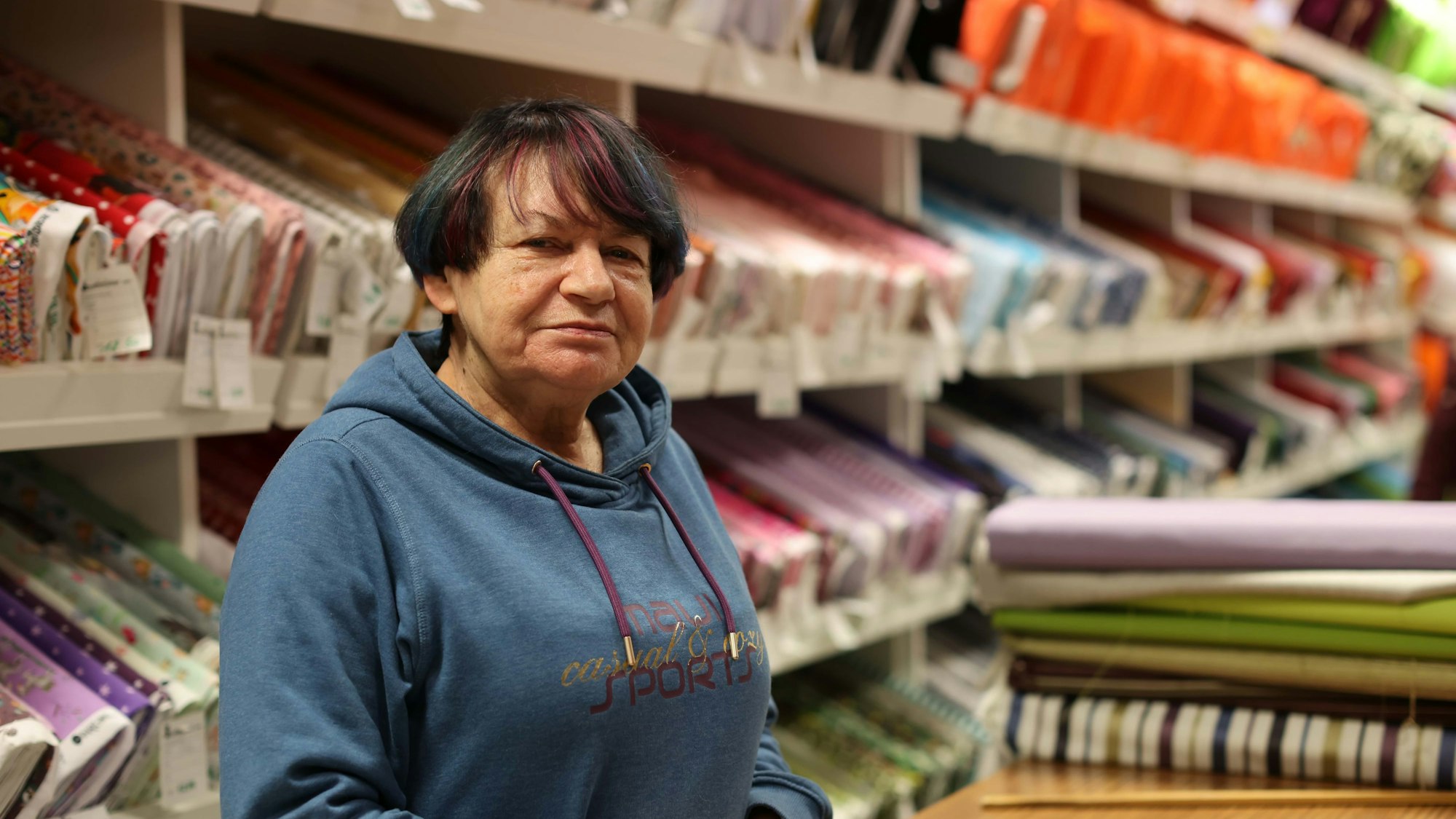 Eine Frau zwischen Stoffballen.